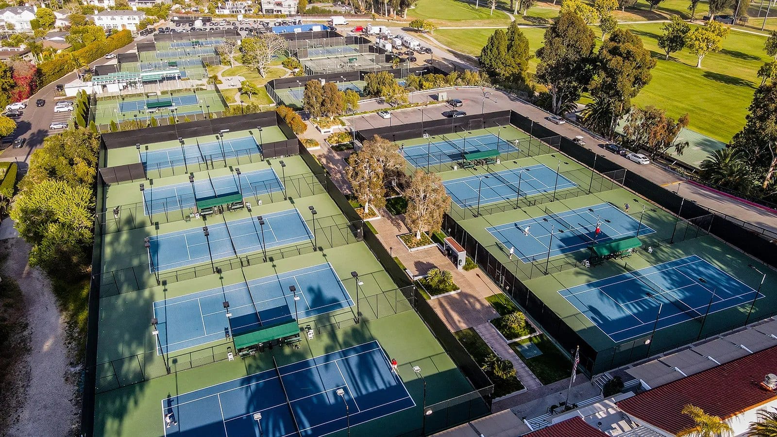 Vista aérea de um clube com várias quadras de tênis azuis